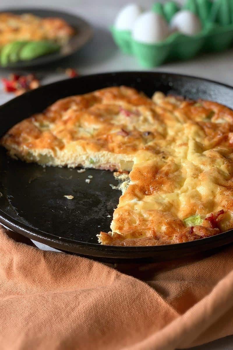 Sliced spicy bacon frittata in a cast iron skillet
