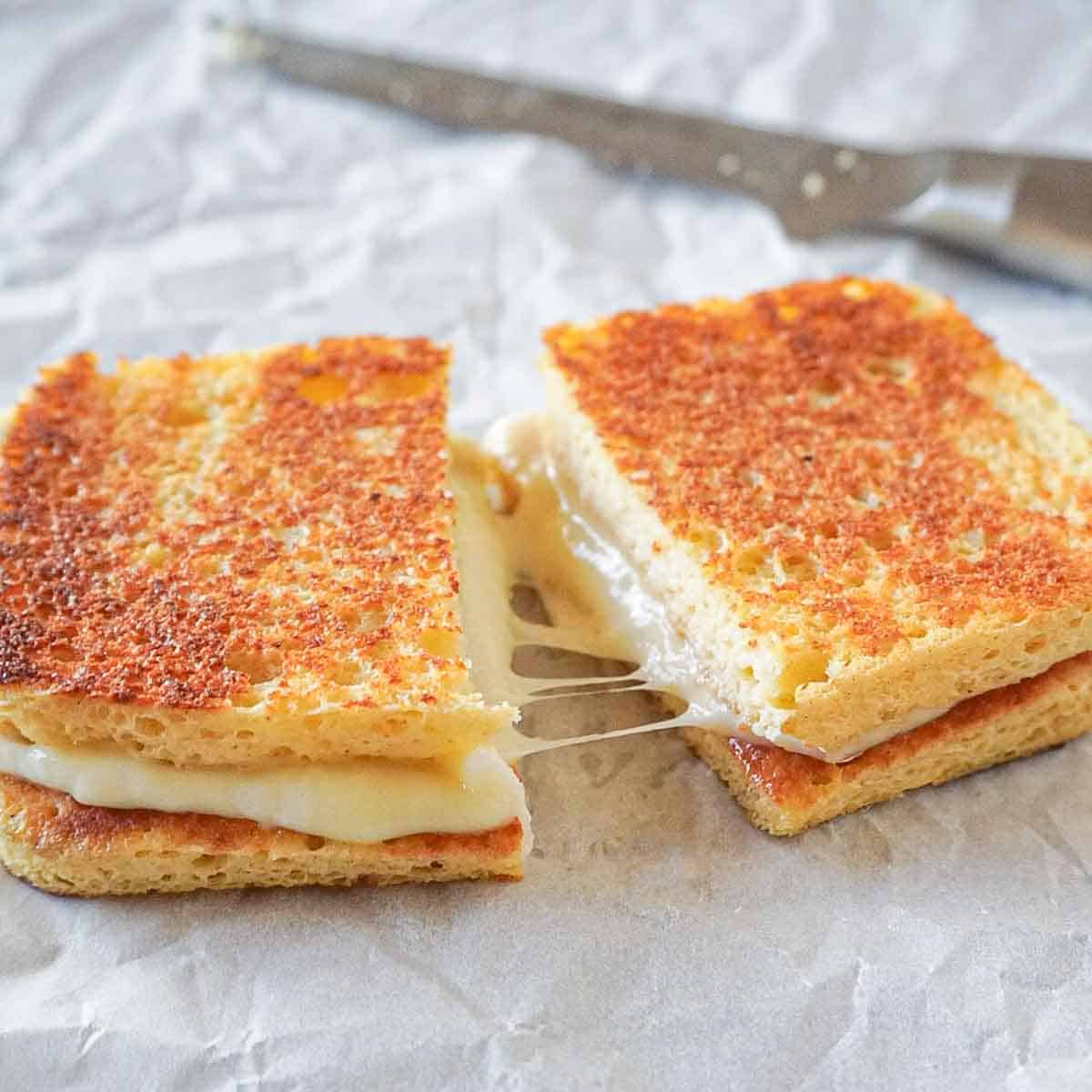 Gluten-free and low carb grilled cheese sandwich cutter in half with stringy mozzarella and gouda cheese.