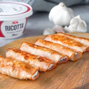 Turkey roll ups with ricotta cheese and garlic on the wooden board.