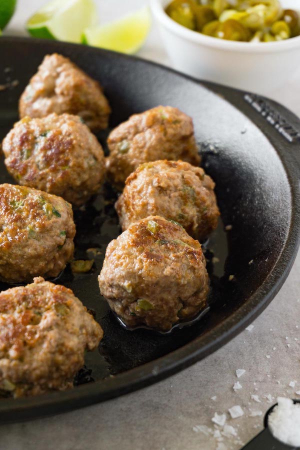 Freshly cooked beef meatballs in a cast-iron skillet.