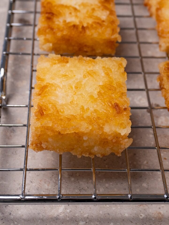 Deep-fried rice cakes on a cooling rack.