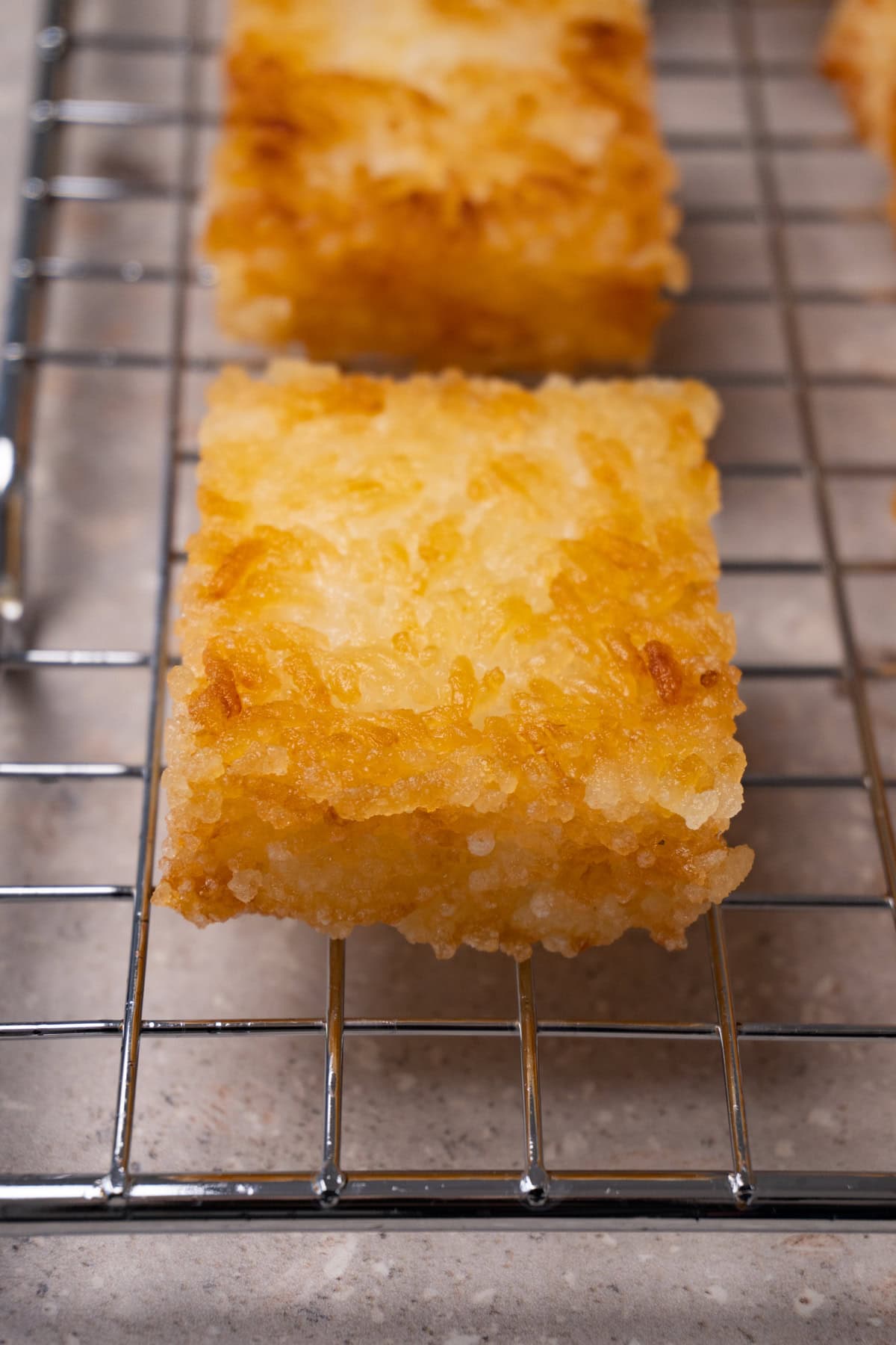 Deep-fried rice cakes on a cooling rack.