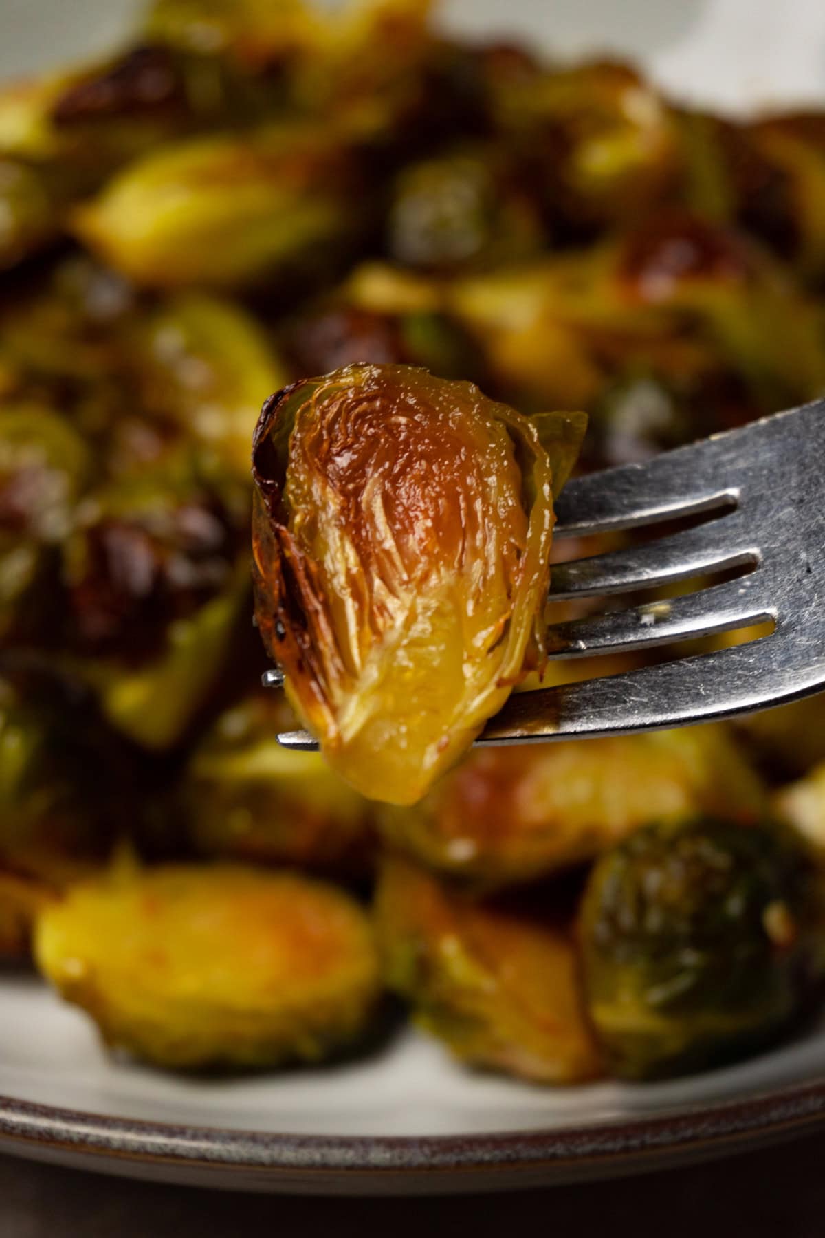 A fork with halved baked Brussels sprouts.