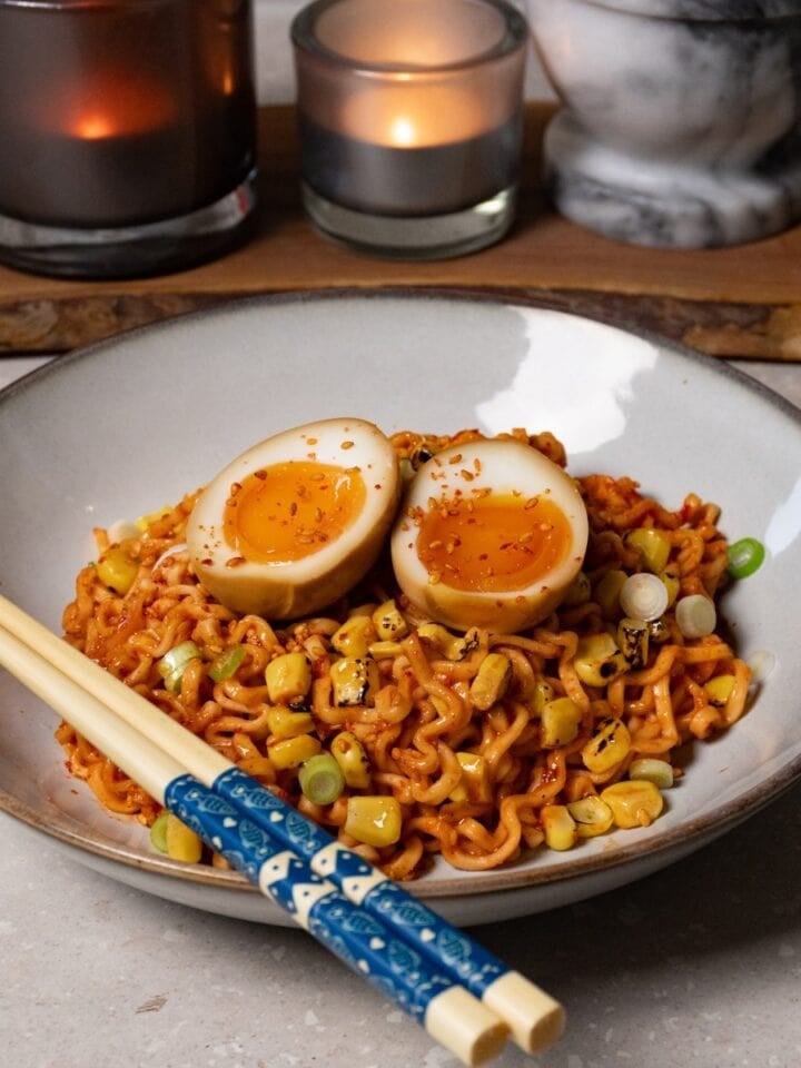 A bowl of noodles topped with jammy soy sauce eggs.